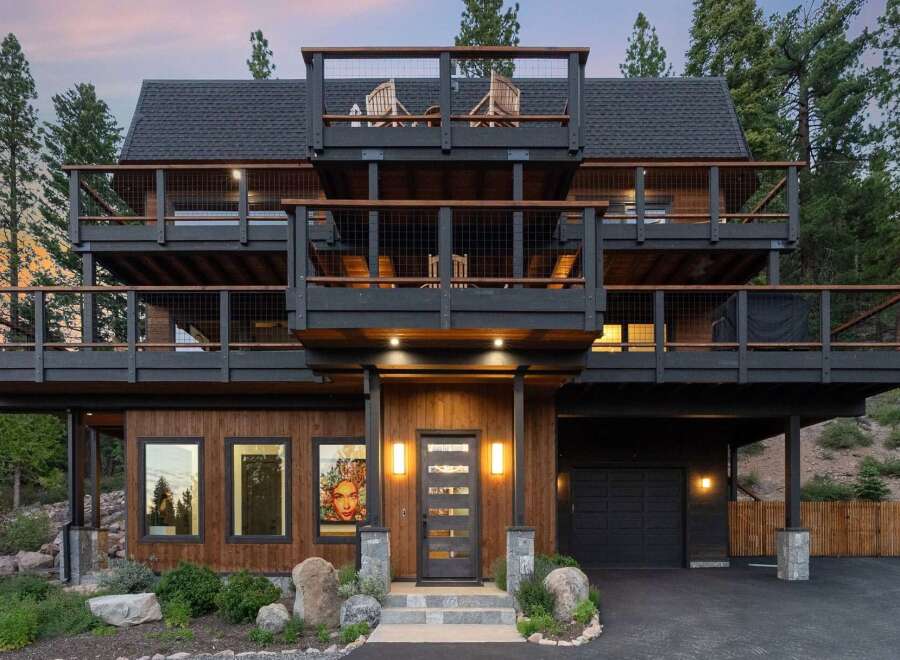 Experience modern mountain living in this stunning multi-level home, featuring expansive decks perfect for enjoying the surrounding forest views.