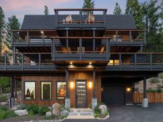Experience modern mountain living in this stunning multi-level home, featuring expansive decks perfect for enjoying the surrounding forest views.