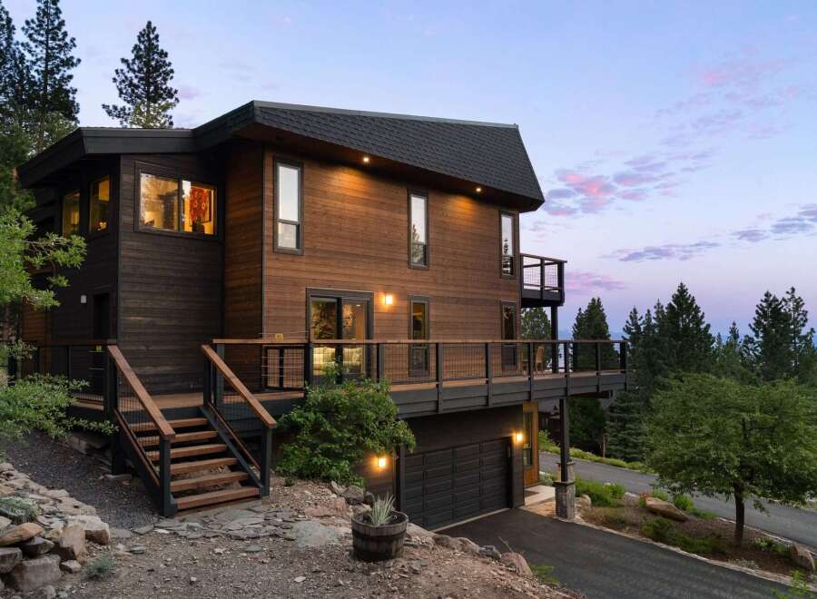 Experience modern mountain living in this stunning wood-clad home, featuring expansive decks perfect for enjoying the serene natural surroundings.