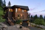 Experience modern mountain living in this stunning wood-clad home, featuring expansive decks perfect for enjoying the serene natural surroundings.