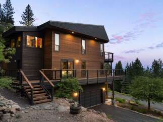 Experience modern mountain living in this stunning wood-clad home, featuring expansive decks perfect for enjoying the serene natural surroundings.