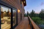 Experience seamless indoor-outdoor living with this stunning modern home featuring expansive sliding glass doors that open onto a spacious wooden deck.