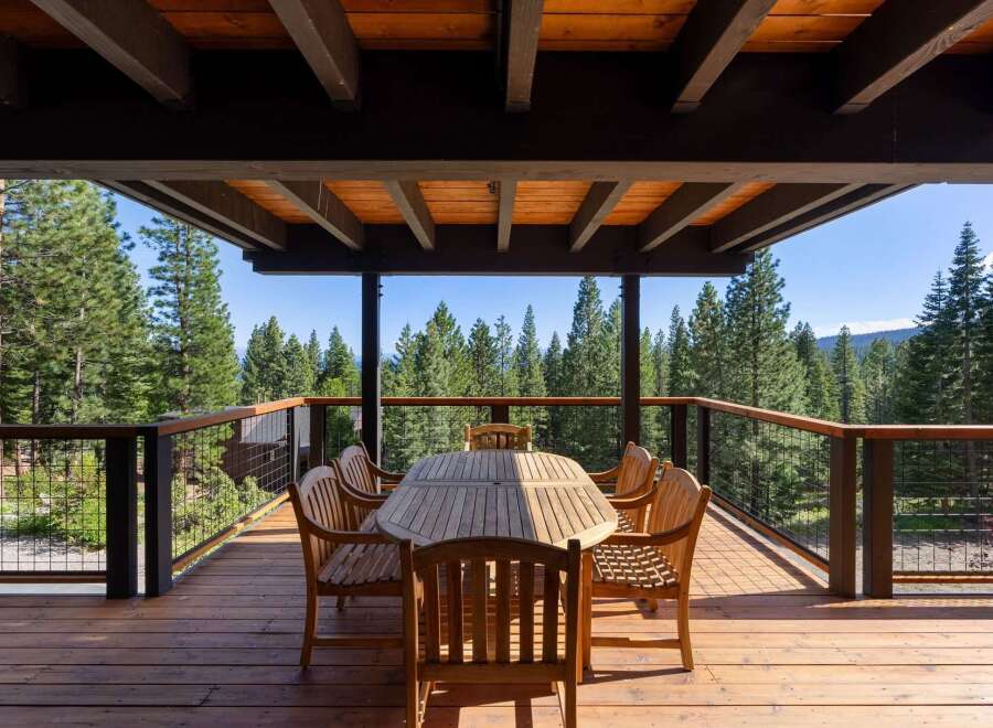 Enjoy breathtaking forest views from this expansive wooden deck, perfect for outdoor dining and entertaining.