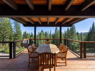 Enjoy breathtaking forest views from this expansive wooden deck, perfect for outdoor dining and entertaining.