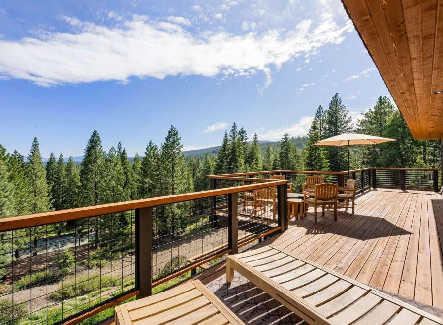 Enjoy breathtaking forest views from this expansive wooden deck, perfect for outdoor living and entertaining.
