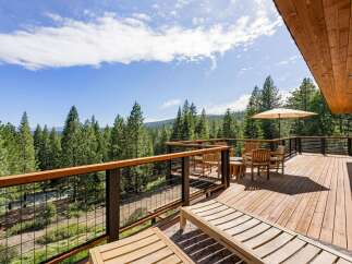 Enjoy breathtaking forest views from this expansive wooden deck, perfect for outdoor living and entertaining.