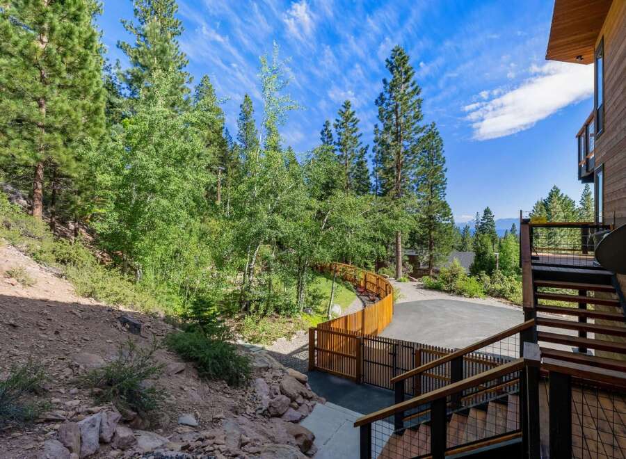 Discover this stunning mountain retreat featuring a modern wooden exterior and expansive decks perfect for enjoying the serene forest views.
