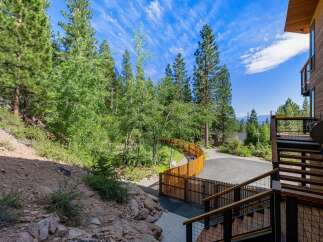Discover this stunning mountain retreat featuring a modern wooden exterior and expansive decks perfect for enjoying the serene forest views.