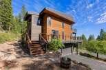 Experience modern mountain living in this stunning contemporary home, featuring warm wood siding and expansive decks perfect for enjoying the surrounding forest views.