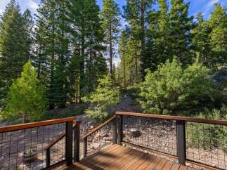 Enjoy the serene mountain views from this beautiful deck, surrounded by lush pine trees.