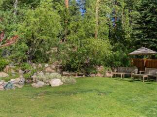Enjoy the serene backyard oasis featuring a charming water feature and lush greenery, perfect for relaxation.
