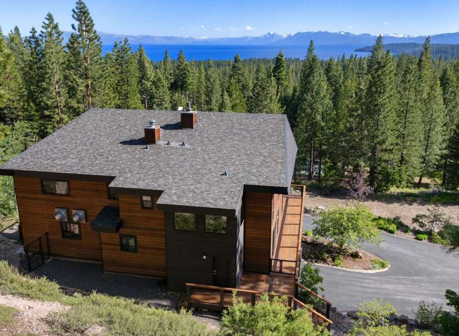 Experience breathtaking lake and mountain views from this stunning modern home nestled among tall pine trees.