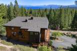 Experience breathtaking lake and mountain views from this stunning modern home nestled among tall pine trees.