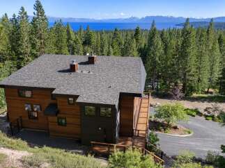 Experience breathtaking lake and mountain views from this stunning modern home nestled among tall pine trees.