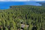 Nestled within a dense forest, this property offers a serene escape with stunning lake views in the distance.