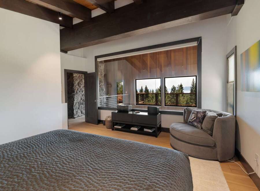 Experience luxurious living in this master bedroom, featuring a plush king-sized bed with a textured comforter.