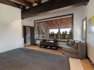 Experience luxurious living in this master bedroom, featuring a plush king-sized bed with a textured comforter.