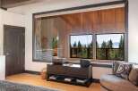 Experience breathtaking lake and mountain views from this stunning bedroom, featuring expansive windows that bring the outdoors in.