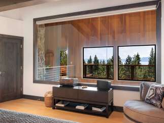 Experience breathtaking lake and mountain views from this stunning bedroom, featuring expansive windows that bring the outdoors in.