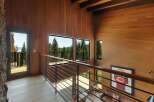 Experience breathtaking natural beauty from this stunning modern home, featuring expansive windows that frame panoramic views of lush forests and a serene lake.