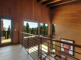 Experience breathtaking natural beauty from this stunning modern home, featuring expansive windows that frame panoramic views of lush forests and a serene lake.