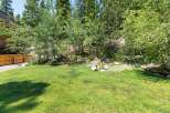 Enjoy the serene backyard oasis, complete with a lush green lawn perfect for outdoor activities.