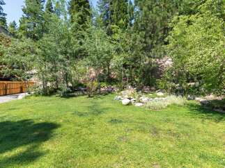 Enjoy the serene backyard oasis, complete with a lush green lawn perfect for outdoor activities.