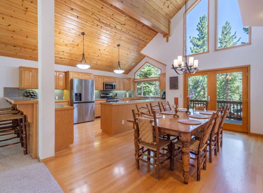 Experience rustic charm in this spacious kitchen and dining area, featuring warm wood ceilings and ample natural light.