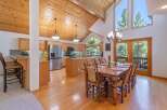 Experience rustic charm in this spacious kitchen and dining area, featuring warm wood ceilings and ample natural light.