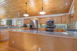 Experience the warmth of this inviting kitchen, featuring beautiful natural wood cabinetry and a spacious granite-topped island perfect for meal prep and casual dining.