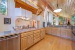 Experience rustic charm in this spacious kitchen featuring vaulted wood-beamed ceilings and a large island perfect for entertaining.