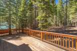 Enjoy the serene mountain lifestyle from this spacious wooden deck, perfect for outdoor entertaining or simply relaxing amidst the towering pine trees.