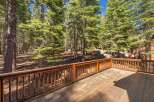 Enjoy the serene mountain lifestyle from this spacious wooden deck, perfect for outdoor entertaining or quiet relaxation amidst a lush pine forest.