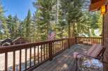 Enjoy the serene mountain views from this charming wooden deck, complete with comfortable seating and a glass-top table.