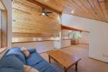 Experience rustic charm in this loft living area, featuring a vaulted wood-paneled ceiling and a cozy blue sofa.