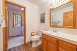 This charming bathroom features a classic wooden vanity with a white tiled countertop and a spacious sink.