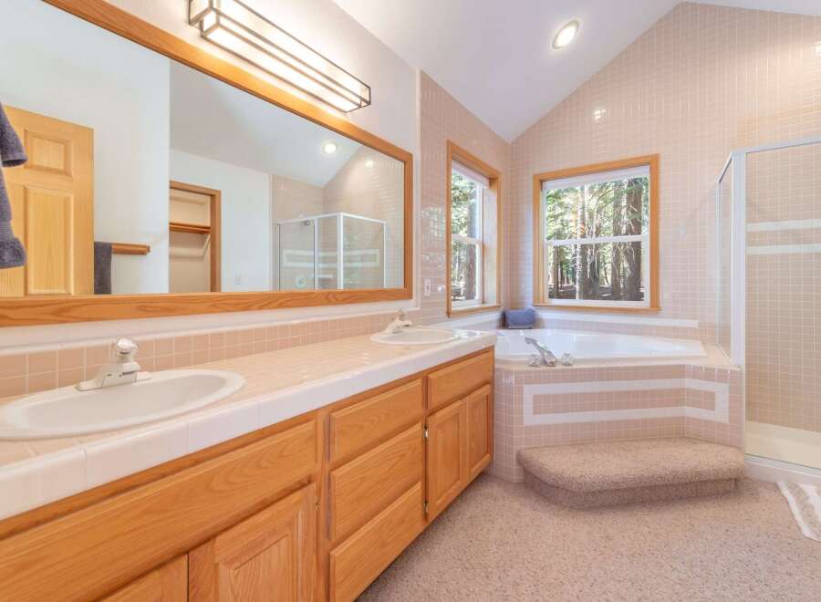 This charming bathroom features a spacious double vanity with ample counter space and elegant wooden cabinetry.