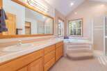 This charming bathroom features a spacious double vanity with ample counter space and elegant wooden cabinetry.