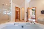 Experience luxury and convenience in this spacious bathroom featuring a large soaking tub and a separate glass-enclosed shower.