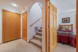 Step into this charming home featuring a cozy entryway with two wooden doors and a carpeted staircase leading to the upper level.