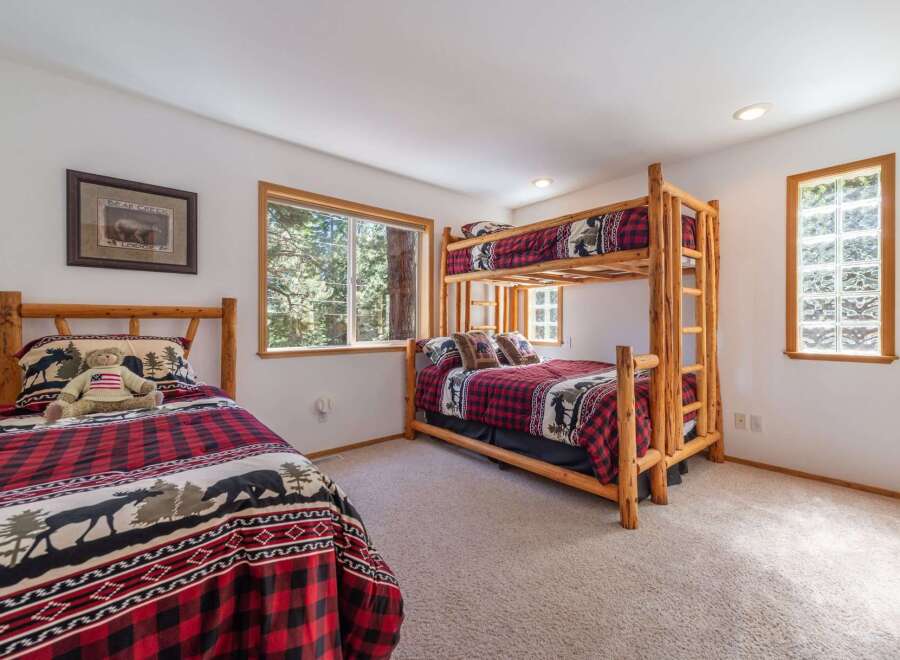 This charming bedroom features a cozy bunk bed and a separate twin bed, perfect for accommodating family or guests.