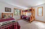 This charming bedroom features a cozy bunk bed and a separate twin bed, perfect for accommodating family or guests.