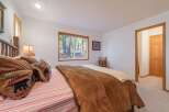 Experience rustic charm in this cozy bedroom, featuring a comfortable bed adorned with bear-themed pillows and a plush brown comforter.