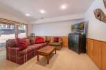 Cozy up in this inviting living room featuring a patterned sofa with plush red throw pillows and a matching armchair.