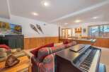 This basement living area offers a perfect blend of entertainment and relaxation, featuring a large flat-screen TV, a pool table, and a ping pong table.