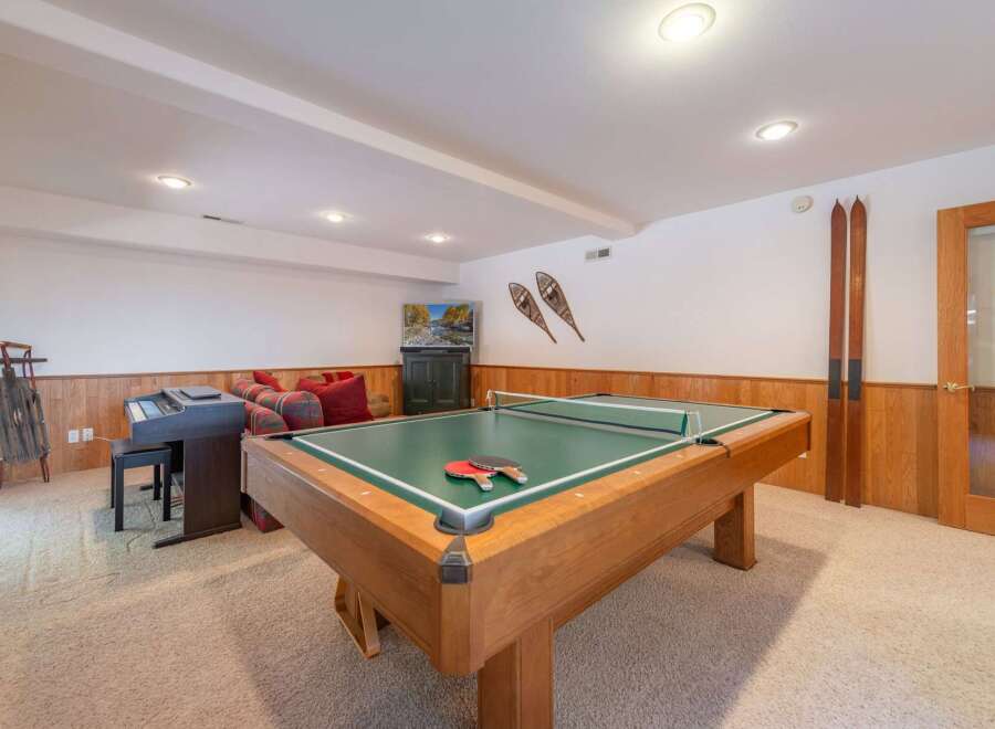 This recreational room offers a perfect blend of entertainment and relaxation, featuring a versatile pool table that can also be used for ping pong.