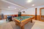 This recreational room offers a perfect blend of entertainment and relaxation, featuring a versatile pool table that can also be used for ping pong.