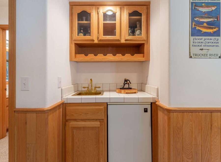 This charming wet bar features a beautiful oak cabinet with glass-fronted doors, perfect for displaying your favorite spirits.