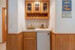 This charming wet bar features a beautiful oak cabinet with glass-fronted doors, perfect for displaying your favorite spirits.