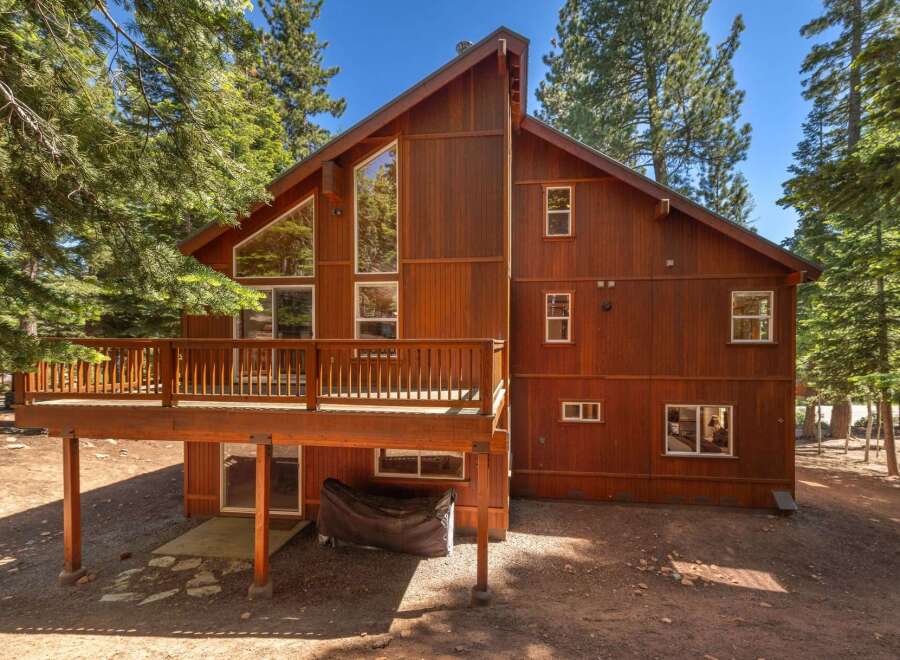 Experience mountain living in this stunning wood-sided home, featuring a spacious wrap-around deck perfect for outdoor entertaining and enjoying the serene forest surroundings.